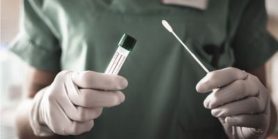 Someone in scrubs holding a swab and a test tube