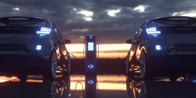 Electric cars charging at a charging station at sunset