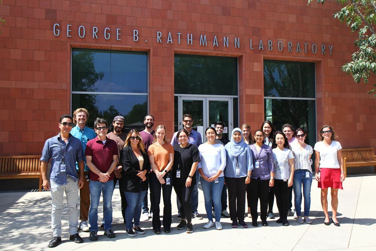 Group photo of staff at Amgen's headquarters in Thousand Oaks, California, standing in front of the George B. Rathmann Laboratory building