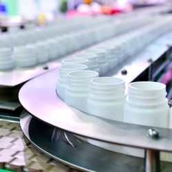Close-up of pharmaceutical bottling plant production line.