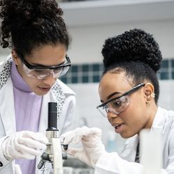 Black female teenage student learning to use a microscope